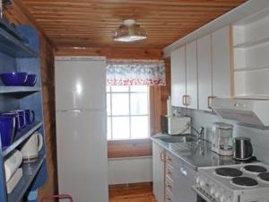 a kitchen with a white refrigerator and a window at Holiday Home Juolukka by Interhome in Pulju