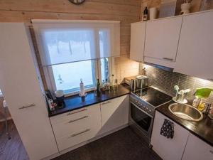 a kitchen with white cabinets and a window and a sink at Holiday Home Oppas lapland levi by Interhome in Levi
