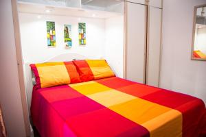 um quarto com uma cama listrada colorida num quarto em Apartamento Djalma Urich no Rio de Janeiro
