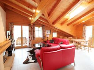 sala de estar con sofá rojo y mesa en Apartment Farfalla by Interhome, en Gstaad