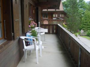uma varanda com uma mesa e cadeiras numa casa em Apartment Arnika # 2 by Interhome em Lenk