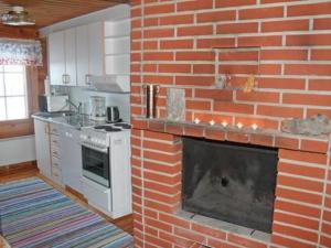 a brick fireplace in the middle of a kitchen at Holiday Home Juolukka by Interhome in Pulju