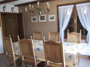 uma sala de jantar com uma mesa com cadeiras e um lustre em Apartment Arnika # 2 by Interhome em Lenk