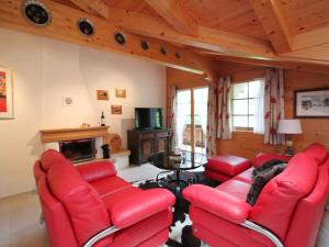 sala de estar con sillas rojas y chimenea en Apartment Farfalla by Interhome, en Gstaad