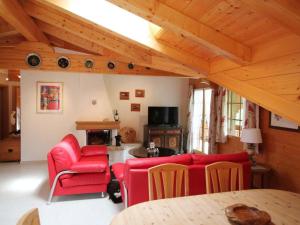 un soggiorno con tavolo e sedie rosse di Apartment Farfalla by Interhome a Gstaad