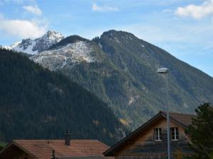 a house with a mountain in the background at Apartment Simmental by Interhome in Zweisimmen