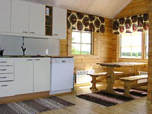 eine Küche mit weißen Geräten und einem Tisch in einer Hütte in der Unterkunft Holiday Home Iso marina by Interhome in Karvonen