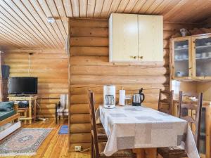 una sala da pranzo con tavolo e TV di Holiday Home Lähde by Interhome a Luosto