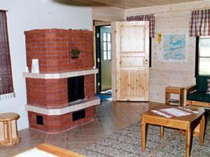 een woonkamer met een bakstenen open haard en een deur bij Holiday Home Mäntyaho by Interhome in Karvonen