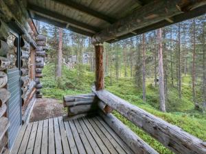 um alpendre de uma cabana na floresta em Holiday Home Ylläsrivit c 8 - villa änkyrä by Interhome em Ylläsjärvi