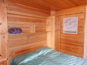 um chalé de madeira com uma cama num quarto em Holiday Home Takaharju by Interhome em Karvonen