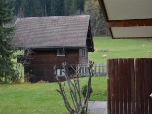 ツヴァイジンメンにあるApartment Simmental by Interhomeの動物を背景にした野原の木造小屋