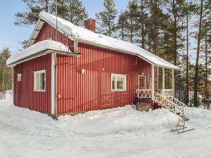 uma casa vermelha com neve em cima em Holiday Home Levin mummola by Interhome em Köngäs