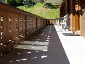 a porch with a table and chairs on a house at Apartment Graebi by Interhome in Gstaad