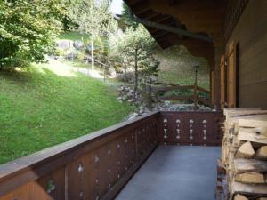 a porch of a house with a wooden fence at Apartment Graebi by Interhome in Gstaad