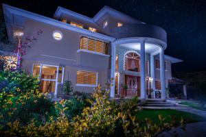 ein großes Haus in der Nacht mit eingeschaltetem Licht in der Unterkunft Hotel Casa Sayu in Tumbaco