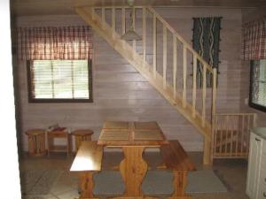 einen Holztisch in einem Zimmer mit einer Treppe in der Unterkunft Holiday Home Mäntyaho by Interhome in Karvonen
