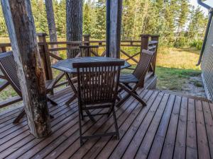 eine Holzterrasse mit einem Tisch und Stühlen darauf in der Unterkunft Holiday Home Björn by Interhome in Hitis