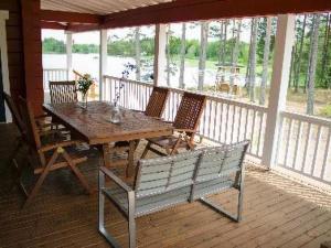 un tavolo in legno e una panca su un portico con tavolo e sedie di Holiday Home Pernoo 3 by Interhome a Pernoo