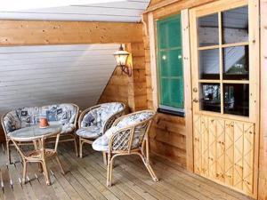 eine Terrasse mit Stühlen und einem Tisch auf einer Veranda in der Unterkunft Holiday Home Linnunlaulu by Interhome in Atro