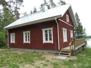 una casa roja con techo blanco y porche en Holiday Home Karri by Interhome, en Tallnäs