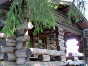 una baita di tronchi con finestra e pila di tronchi di Holiday Home Kelo-kolo by Interhome a Iisalmi