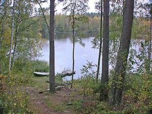 a boat sitting on the shore of a lake at Holiday Home Mustikka by Interhome in Röylä