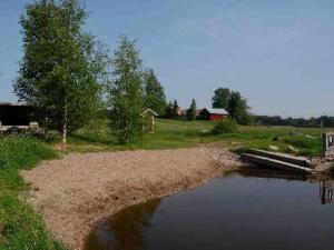 un cuerpo de agua con un puente junto a un campo en Holiday Home Louhela by Interhome, en Kisko