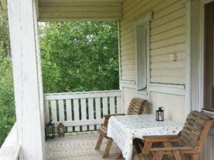 Un patio con una mesa y sillas en un porche. en Holiday Home Hurran ranta by Interhome, en Rautela