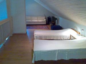 a attic room with two beds and a couch at Holiday Home Karri by Interhome in Tallnäs