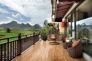 balcone con sedie e vista sulle montagne. di Peach Blossom Resort Hotel a Guilin