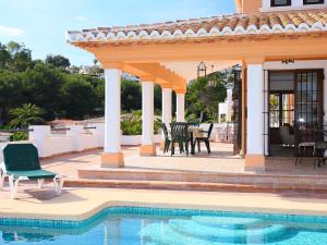 a patio with a table and chairs and a pool at Villa Ca Toni by Interhome in Moraira