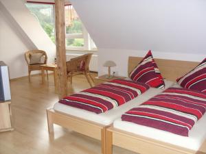 a couch with pillows on it in a living room at Pension Fitnessoase in Eußenheim