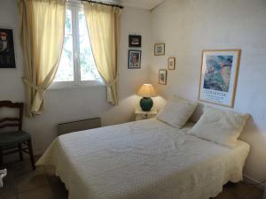 sypialnia z białym łóżkiem i oknem w obiekcie Holiday Home Les Mas de Cogolin by Interhome w mieście Cogolin