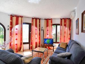 uma sala de estar com um sofá e uma televisão em Holiday Home Wolf by Interhome em Balcon del Mar