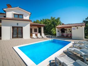 a villa with a swimming pool and chairs at Holiday Home Dorijano by Interhome in Ripenda Kras