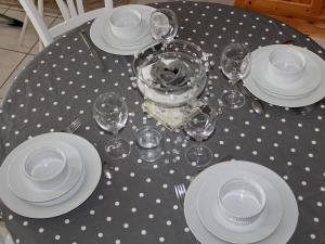 una mesa con platos y gafas sobre un paño de mesa de lunares en Chalet Le Clos des Sapins by Interhome, en Monlet