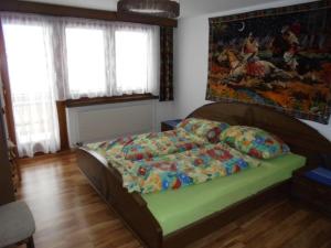 - une chambre avec un lit et une peinture murale dans l'établissement Apartment Silberdistel by Interhome, à Saas-Grund