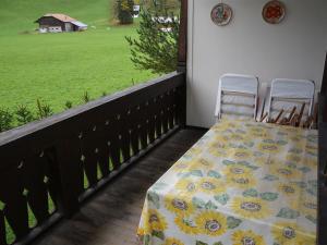 una mesa y sillas en un balcón con vistas a un campo en Apartment Oberland Nr- 7 by Interhome en Gstaad