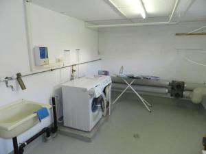 a hospital room with a sink and a washing machine at Apartment Suzanne Nr- 18 by Interhome in Gstaad