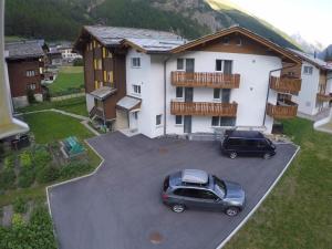 zwei Autos auf einem Parkplatz vor einem Haus geparkt in der Unterkunft Apartment Weideli by Interhome in Saas-Grund