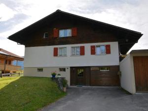 a large white house with a large garage at Apartment Mutzli by Interhome in Saanenmöser