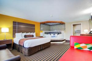 a hotel room with a large bed and a couch at Westbridge Inn & Suites in Clinton +37 photos