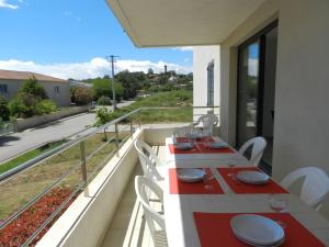 San-GiulianoにあるApartment Lup - Les terrasses d'Alistro by Interhomeのバルコニー(赤と白のテーブル、椅子付)