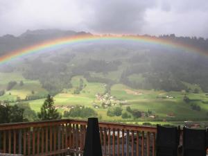 Un arcobaleno su una verde vallata con un arcobaleno di Apartment Nubes- Chalet by Interhome a Zweisimmen