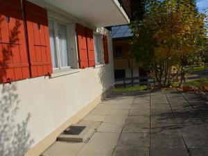 a building with red shutters on the side of it at Apartment Mutzli by Interhome in Saanenmöser