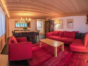 a living room with red couches and a dining room at Apartment Les Silenes by Interhome in Gstaad