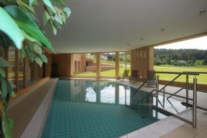 une maison avec une piscine au milieu dans l'établissement Natur & Wellnesshotel Breggers Schwanen - Bernau im Schwarzwald, à Bernau im Schwarzwald