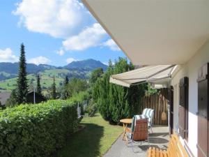 a patio with a table and chairs on a house at Apartment Fink by Interhome in Zweisimmen