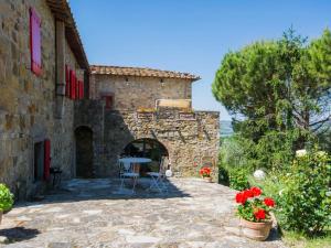 an external view of a stone house with a table and flowers at Apartment Badia a Passignano-3 by Interhome in Badia A Passignano